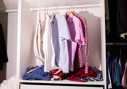 Messy Closet, Wardrobe With Dangling Unfolded Man's Clothes, Scattered Things, Shirts on Hangers. Junk Drawer. Clean That Mess Concept, Organize Your Dresser, Solutions, Horizontal Plane.