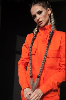 portrait of a beautiful woman with braids in orange work clothes