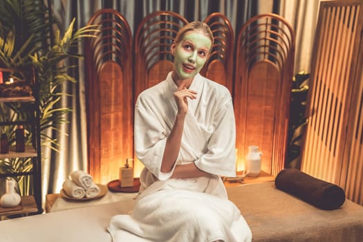 Serene ambiance of spa salon, woman customer indulges in rejuvenating with luxurious face cream massage with warm lighting candle. Facial skin treatment and beauty care concept. Quiescent