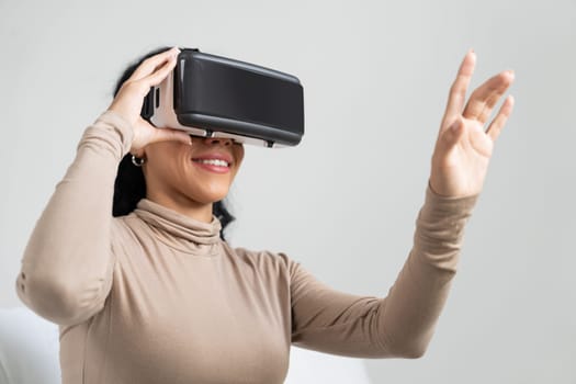 Young woman using virtual reality VR goggle at home for crucial online shopping experience. The virtual reality VR innovation optimized for female digital entertainment lifestyle.