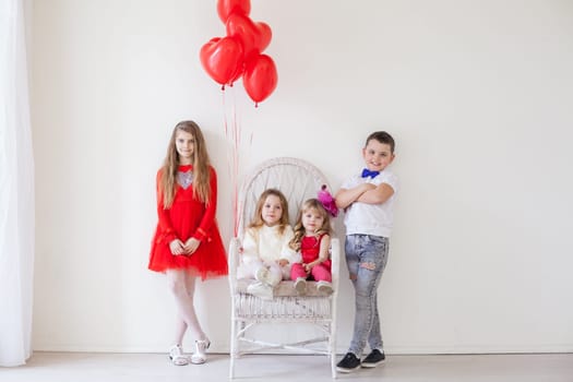 three girls and a boy in red and white clothes with balloons Feb.