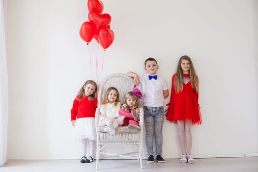 three girls and a boy in red and white clothes with balloons Feb.