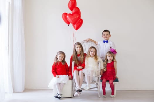 three girls and a boy in red and white clothes with balloons Feb.
