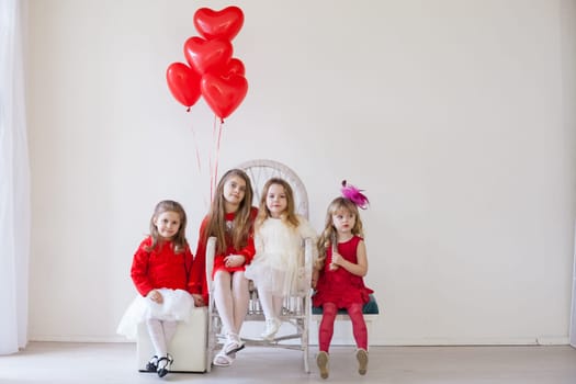 four girls in red and white clothes with balloons in February