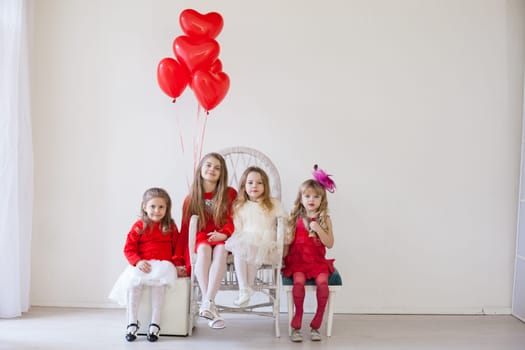 four girls in red and white clothes with balloons in February