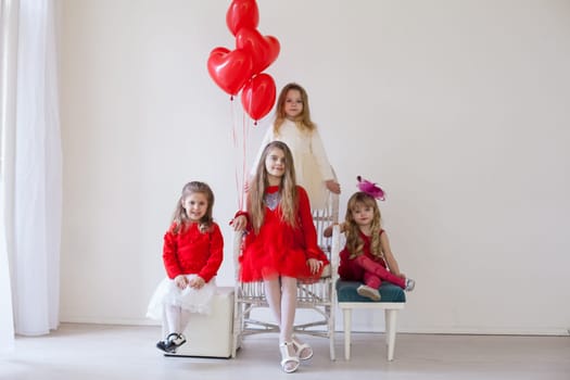 four girls in red and white clothes with balloons in February