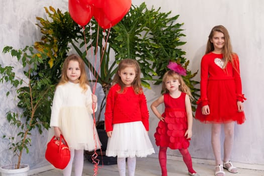 four girls in red and white clothes with balloons in February