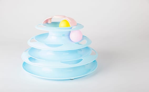 The white backdrop highlights a blue cat tower toy, circular turntable, and a cat's paw gripping a moving ball. It's all about feline intelligence and hunter instincts during playtime.