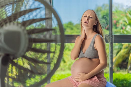 A pregnant woman seeks relief from an abnormal heatwave by using a fan, ensuring her comfort and well-being during sweltering conditions.