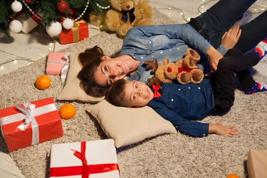 Mom and son on New Year's Eve at Christmas tree gifts lights