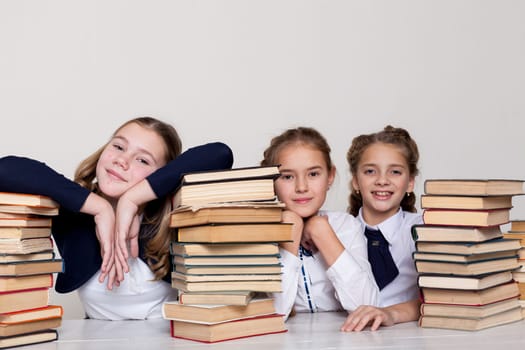 two girls with books in class at a desk at school