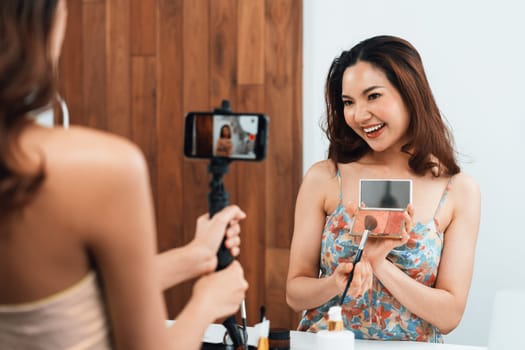 Woman influencer shoot live streaming vlog video review makeup uttermost social media or blog. Happy young girl with cosmetics studio lighting for marketing recording session broadcasting online.