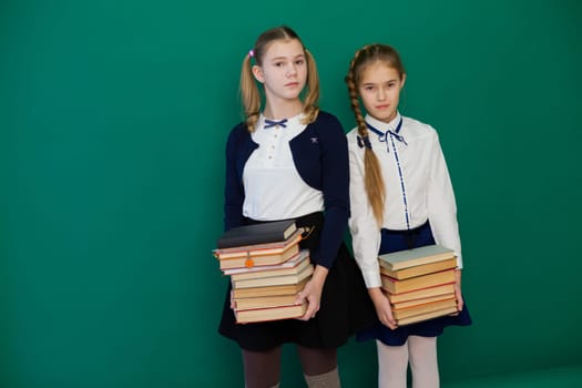 two girls with books in class at the board