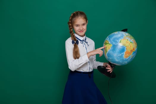girl with a globe in geography class at the board