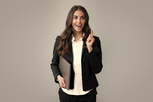 Pretty assistant holding notebook search information internet. Young business woman with laptop computer isolated studio portrait on gray background. Freelancer at work