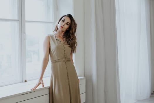 Portrait of a beautiful woman in a beige dress on a walk