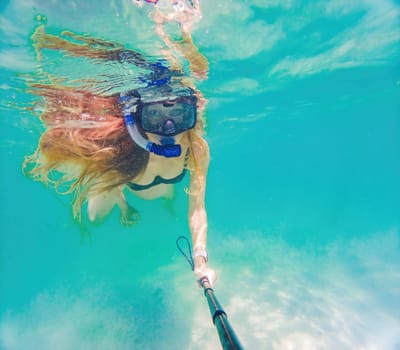 In an ethereal underwater scene, a pregnant woman gracefully floats, embodying the beauty of maternity beneath the tranquil surface of the sea.