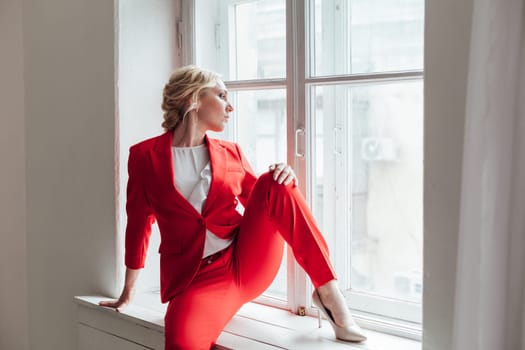 portrait of a woman in a red business suit in the office