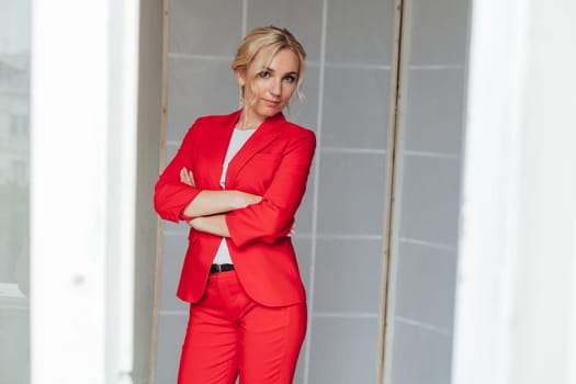 portrait of a woman in a red business suit in the office