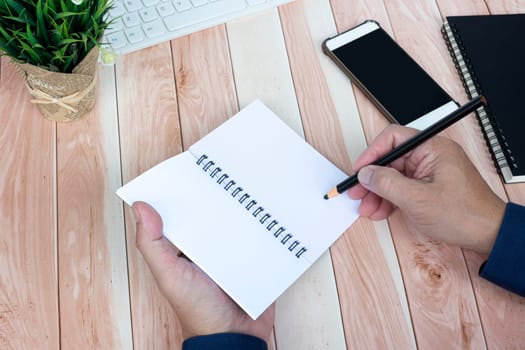 Businessman hands with pen writing notebook on office desk table. Copy space. Business concept.