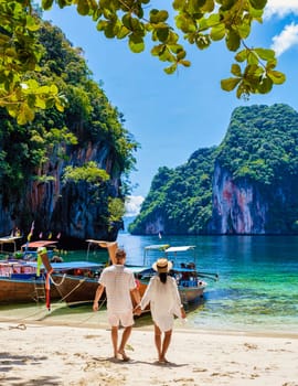 Men and women at the Tropical lagoon of Koh Loa Lading Krabi Thailand part of the Koh Hong Islands in Thailand. beautiful beach with limestone cliffs and longtail boats on a sunny day