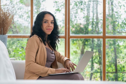 African-American woman using laptop computer for crucial work on internet. Secretary or online content writing working at home.