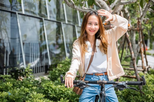 Amidst the city a cheerful young woman shields from the hot sun on her bicycle capturing the beauty of outdoor fun and fashion. This season is all about happiness and nature.