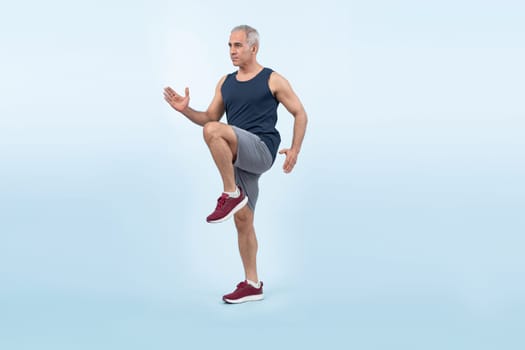 Active and fit physique senior man in sportswear portrait in running posture isolated background. Healthy lifelong senior people with fitness healthy and sporty body care lifestyle concept. Clout