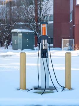 EV charging station on winter season with power trasformator on the background