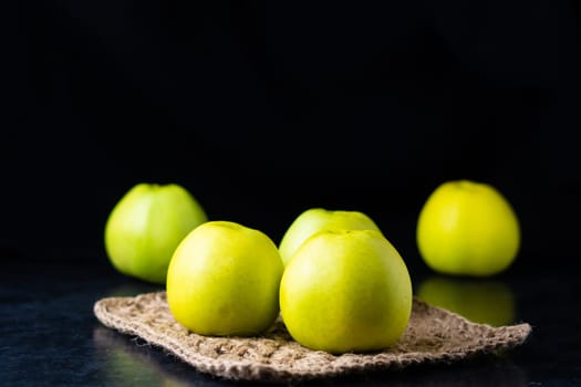 A ripe green apple fruits on a dark stone table. Top view with copy space. Flat lay