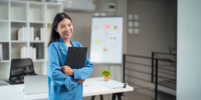 Business woman standing in an office with a smile, mission and vision in the office. management and success with corporate business people at work.