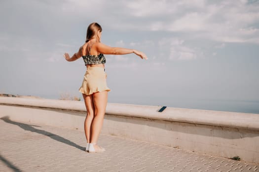 silhouette of a happy woman who dances, spins and raises her hands to the sky. A woman is enjoying a beautiful summer day.