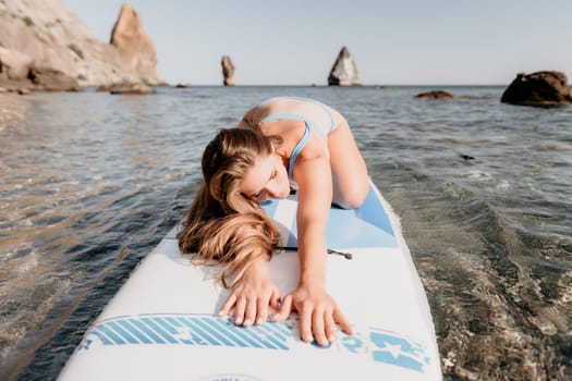 Close up shot of happy young caucasian woman looking at camera and smiling. Cute woman portrait in bikini posing on a volcanic rock high above the sea