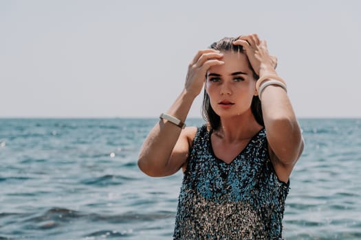 Woman travel sea. Young Happy woman in a long red dress posing on a beach near the sea on background of volcanic rocks, like in Iceland, sharing travel adventure journey