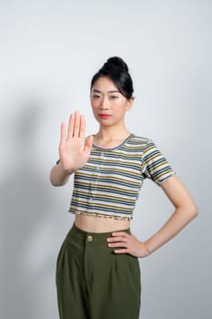 asian young woman looking serious, stern, displeased and angry showing open palm making stop gesture