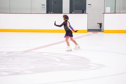 Little girl practicing before her figure skating competition at the indoor ice rink.