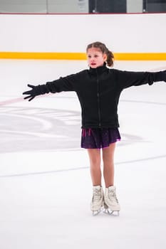 Little girl practicing before her figure skating competition at the indoor ice rink.