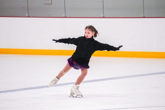 Little girl practicing before her figure skating competition at the indoor ice rink.