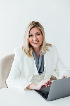works online on a laptop computer, prints text to a project partner. The student manager is sitting on a chair of a young woman of Caucasian appearance. a favorite work, a comfortable business suit
