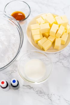 Measured ingredients in glass mixing bowls to make buttercream frosting for American flag mini cupcakes.