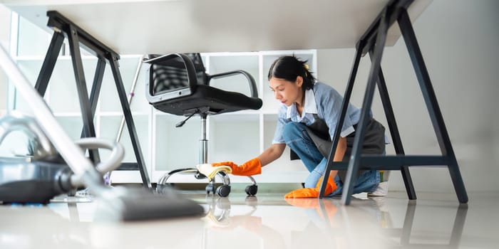 Asian woman cleaning in work room at home. Young woman housekeeper cleaner use a cloth to wipe equipment for working. concept housekeeping housework cleaning.