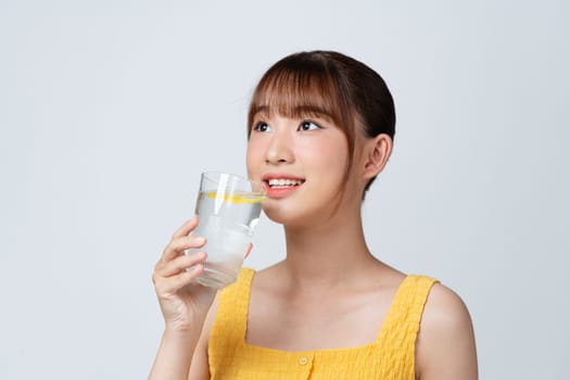 Young woman hold water glass and lemon isolated on white background