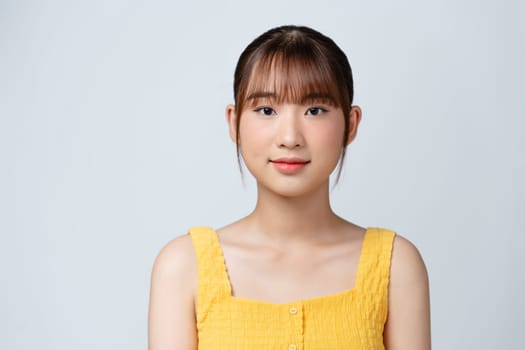 Pretty young woman smiling against a white background