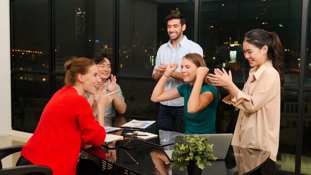 Businesspeople putting hands together and clapping hands to celebrate successful project at modern office with night city view. Group of manager with stacks of hands. Teamwork, trust. Tracery