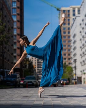 Beautiful Asian ballerina dancing outdoors. Urban landscape