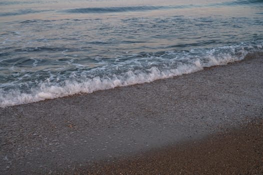 Waves of Mediterranean Sea rolling to the sandy Turkish beach. Beautiful Turkish evening.