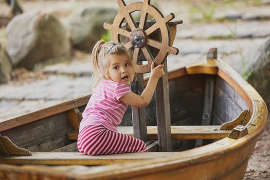 Charming child playing in a toy boat in Denmark.