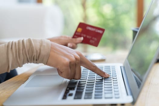 Close up credit card using for online payment, banking and shopping on the internet network with laptop computer showing credit card technology for online secured wallet top up and crucial purchase