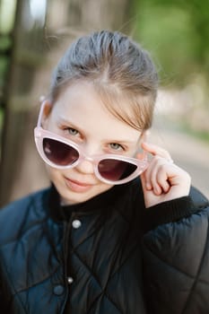 Funny girl playing outdoor surprised emotional child in sunglasses 11 years old girl, family vacations.