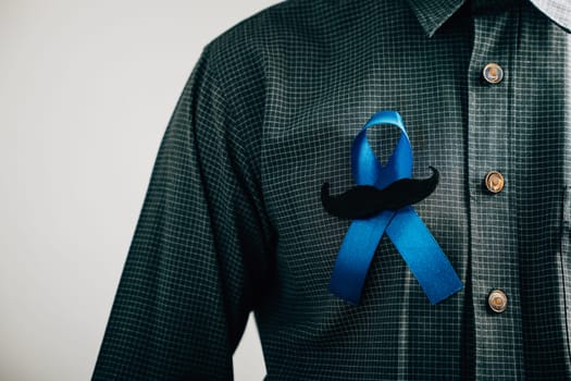 Men's hands exhibit a Blue Ribbon with a moustache, signifying solidarity and support for Colon cancer, Colorectal cancer, Child Abuse awareness, world diabetes day, and International Men's Day.